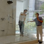 新業(yè)建設(shè)卓勝隆董事長（右）伸手測試三段式水流變化為肌膚帶來的觸感，親身體驗(yàn)，精選出舒心的衛(wèi)浴設(shè)備。