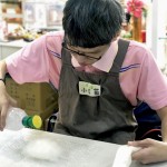 將羊毛絮包覆到皂體上，接著在每一面都進行「氈濕」的程序，讓原本輕盈的羊毛吸收水分後重量增加與皂體緊密貼合，使羊毛皂更好地同時達到滋潤肌膚與去角質(zhì)的作用。