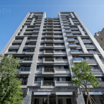 坐落在東區(qū)的自由居，共達154戶，一望無際的藍天襯托出沉穩(wěn)低調(diào)的鐵灰建築外牆。