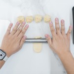 初體驗包月餅的新業(yè)同仁，一步步跟著講師的詳細教學，從秤重、桿捲、包覆、裝飾，到送入烤箱。 