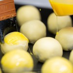 刷上蛋黃液，點上芝麻裝飾，圓潤蓬鬆的蛋黃酥即將穿上金黃酥脆的外衣。