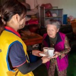 「阿嬤呷飯囉!」，甘霖基金會志工將便當送到獨居長輩手中的同時，也不忘送上一兩句暖心的問候。