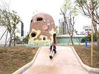 新業(yè)建設(shè)董事長卓勝隆童心大發(fā)，在碉堡地景溜滑梯。