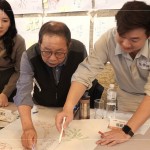 新業(yè)建設(shè)卓勝隆董事長(圖中)與工地主任，共同探討樹木容易死亡的原因，及分析各面向可能的解決方案。