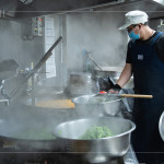 早上六點(diǎn)開(kāi)始，中央廚房與志工著手備餐，馬不停蹄的來(lái)回穿梭，從打菜到分裝都與時(shí)間賽跑著，每個(gè)流程都是滿滿的真心與付出。